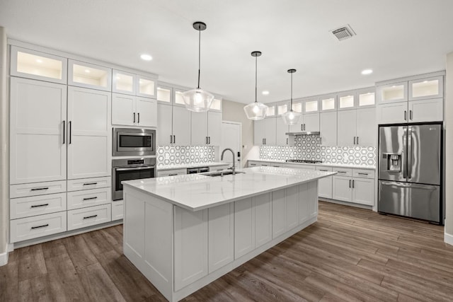 kitchen with a sink, dark wood finished floors, visible vents, and stainless steel appliances