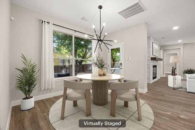 dining area with a chandelier, visible vents, light wood-style floors, and a wealth of natural light