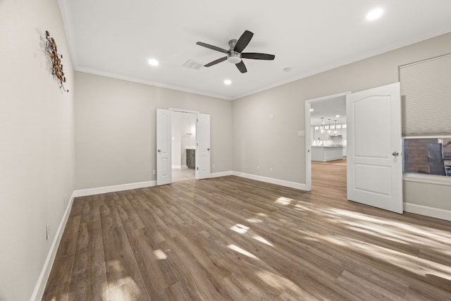 unfurnished bedroom with crown molding, wood finished floors, visible vents, and baseboards