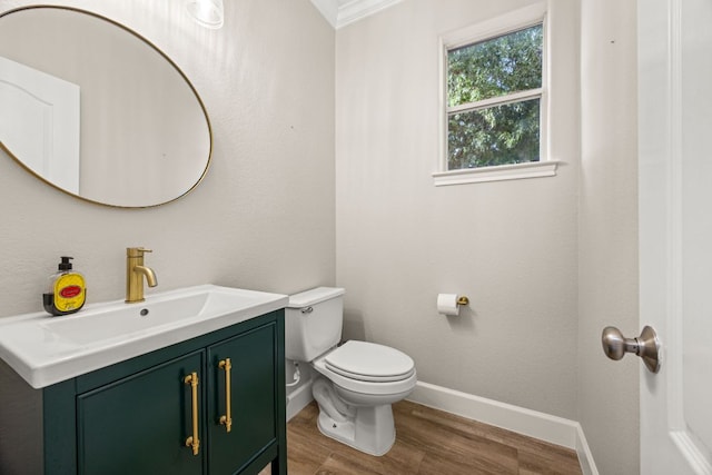 bathroom featuring vanity, toilet, wood finished floors, and baseboards