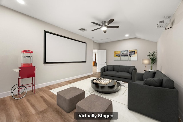 home theater room with a ceiling fan, wood finished floors, visible vents, and baseboards