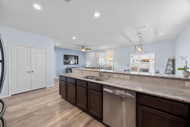 kitchen with visible vents, dark brown cabinetry, light wood-type flooring, stainless steel dishwasher, and a sink