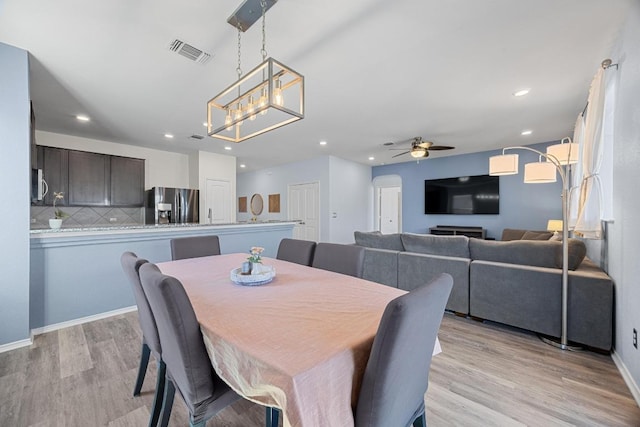 dining room with recessed lighting, visible vents, light wood-style flooring, and ceiling fan with notable chandelier