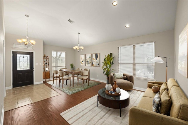 living room with an inviting chandelier, baseboards, visible vents, and light wood-type flooring