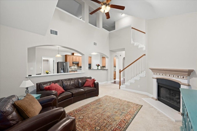 157 Mcgarity, Kyle, TX 78640 - living room with arched walkways, a ceiling fan, stairs, light carpet, and a towering ceiling