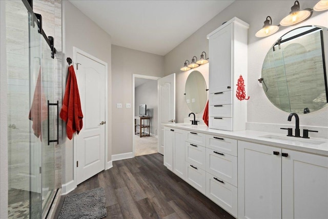 157 Mcgarity, Kyle, TX 78640 - bathroom featuring wood finished floors, double vanity, a stall shower, and baseboards