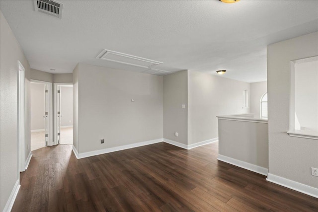 157 Mcgarity, Kyle, TX 78640 - unfurnished room with attic access, dark wood finished floors, and baseboards