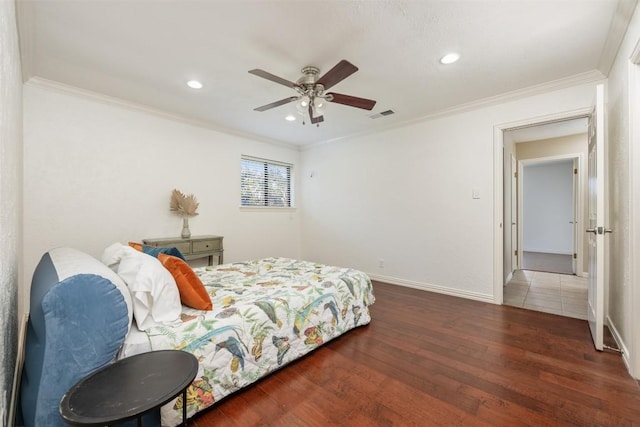 bedroom with visible vents, ornamental molding, a ceiling fan, wood finished floors, and baseboards