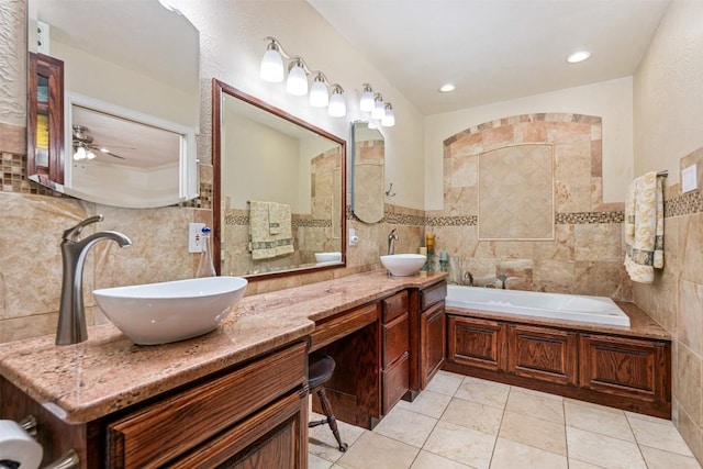 full bath with tile walls, a bathing tub, and a sink