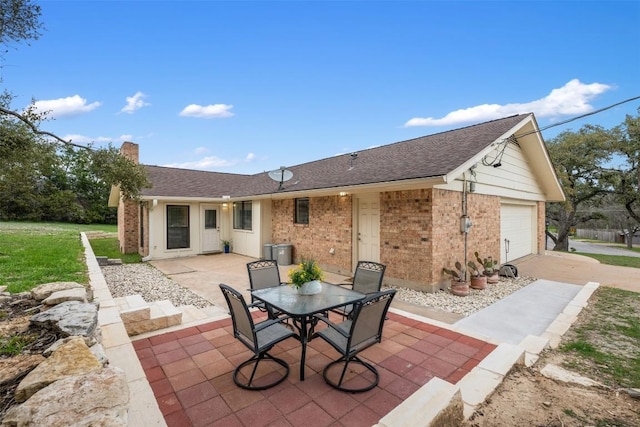 view of patio featuring outdoor dining space, an attached garage, and concrete driveway