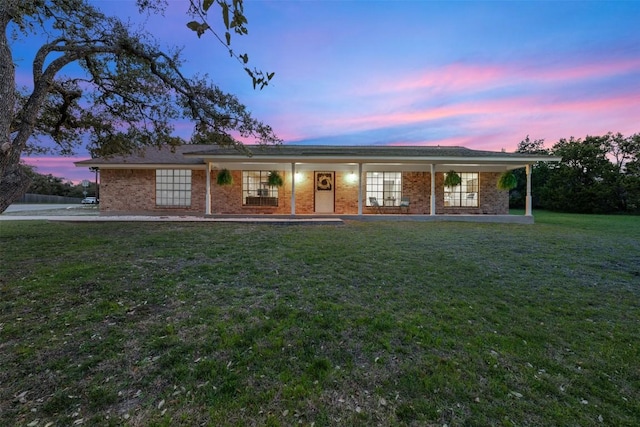 ranch-style house featuring brick siding and a front lawn