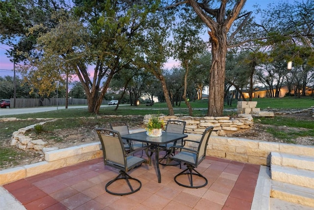 patio terrace at dusk featuring outdoor dining area