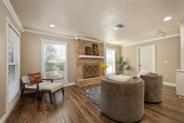 living room with a wealth of natural light, dark wood-type flooring, and a brick fireplace