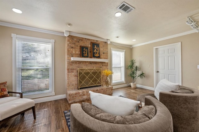 living area featuring visible vents, crown molding, baseboards, and wood finished floors