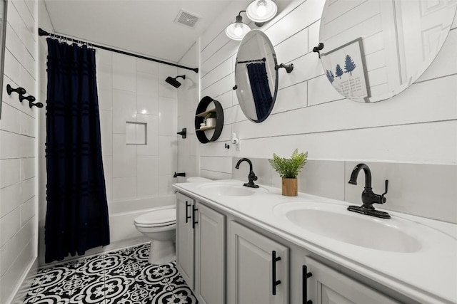 full bathroom featuring a sink, visible vents, toilet, and double vanity