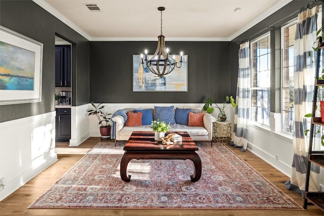 living room with light wood finished floors, visible vents, and a healthy amount of sunlight