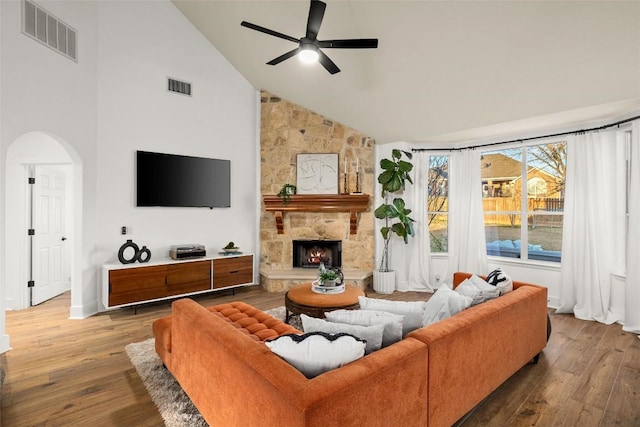 living area featuring arched walkways, visible vents, ceiling fan, and hardwood / wood-style floors