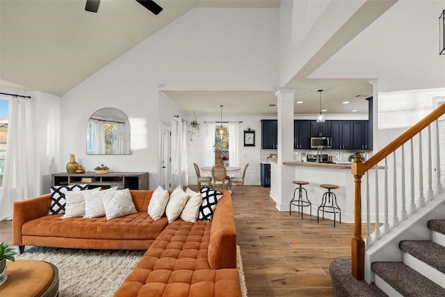 living room featuring stairway, high vaulted ceiling, ceiling fan, and wood finished floors