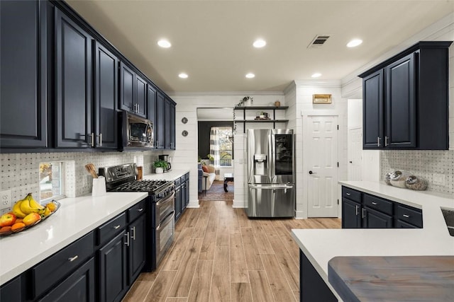 kitchen with light wood-type flooring, stainless steel appliances, visible vents, and light countertops