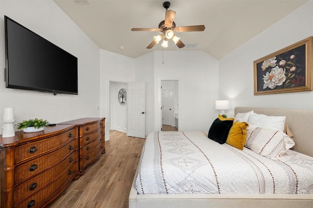 bedroom with visible vents, light wood-style flooring, a ceiling fan, and vaulted ceiling