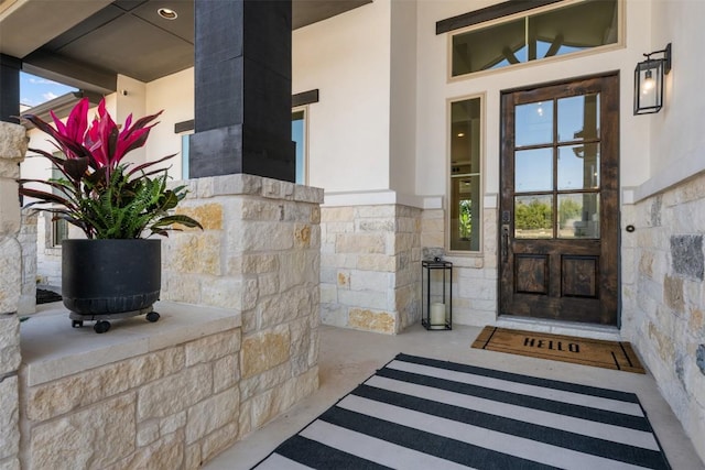 property entrance with stone siding and stucco siding