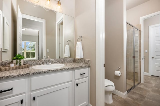 full bath with a stall shower, toilet, vanity, and baseboards