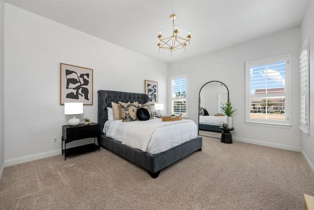 carpeted bedroom with a chandelier and baseboards