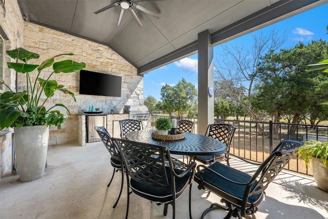 view of patio with outdoor dining area, ceiling fan, and a fireplace