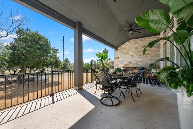 view of patio with outdoor dining area and a ceiling fan