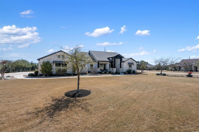 view of front of home featuring a front yard and stone siding