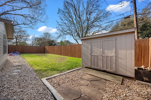 view of yard with an outbuilding, a storage shed, and a fenced backyard