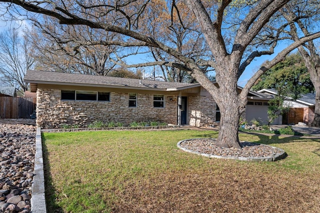 ranch-style house with a front lawn, fence, stone siding, and a shingled roof