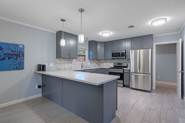 kitchen with a peninsula, a sink, decorative backsplash, light countertops, and appliances with stainless steel finishes