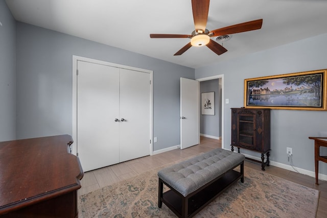 living area featuring visible vents, baseboards, and a ceiling fan