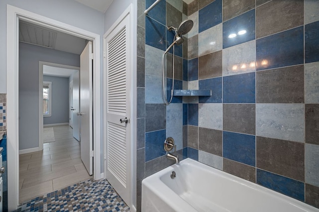 bathroom with bathing tub / shower combination and baseboards