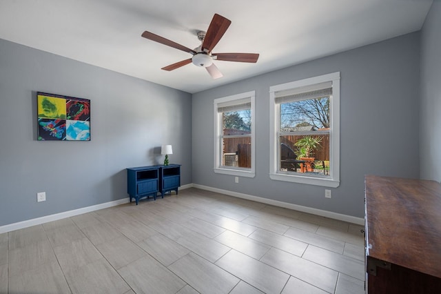 unfurnished office featuring baseboards and ceiling fan