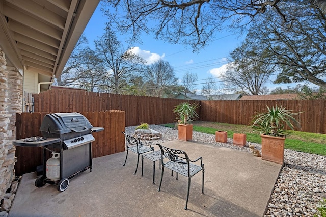 view of patio with grilling area and a fenced backyard