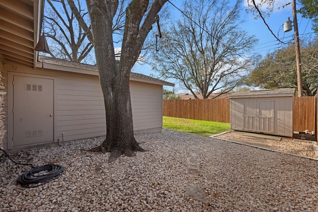 view of yard featuring an outbuilding, a storage shed, and fence