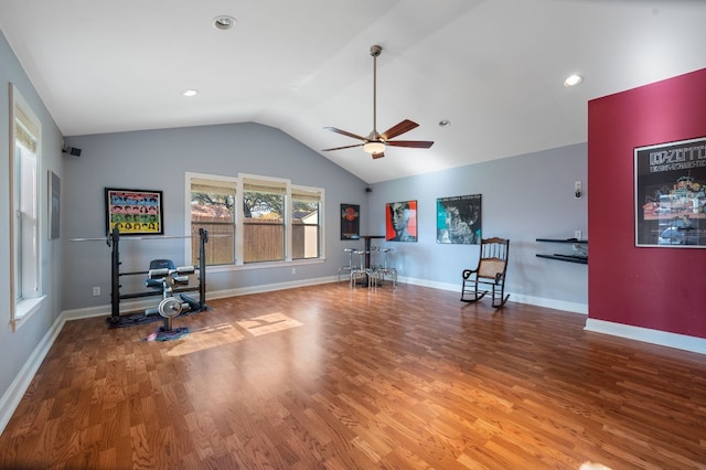 exercise room featuring baseboards, lofted ceiling, a ceiling fan, and wood finished floors