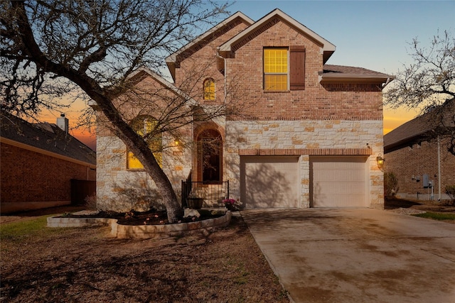 traditional-style house featuring concrete driveway, an attached garage, and stone siding