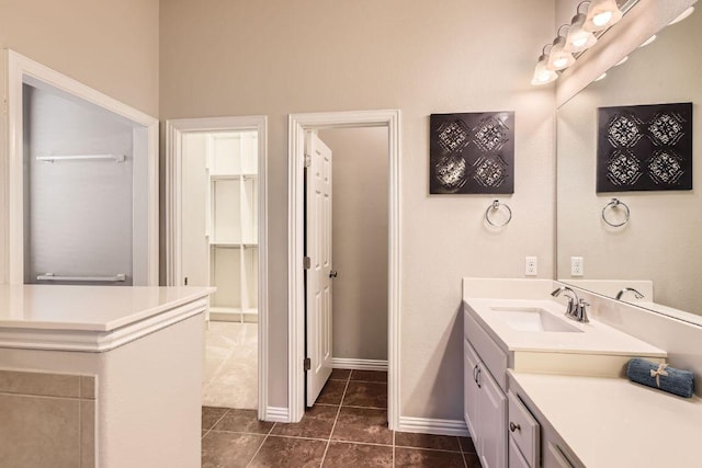 full bath featuring vanity, tile patterned floors, and baseboards