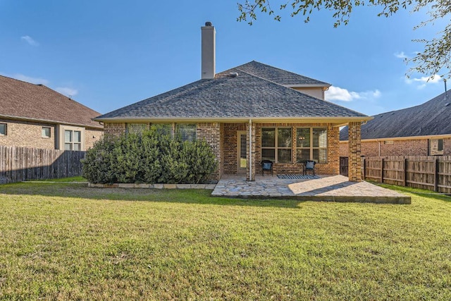 rear view of property featuring a fenced backyard, brick siding, and a yard