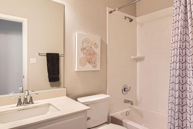 full bath with vanity, toilet, shower / tub combo, and a textured wall