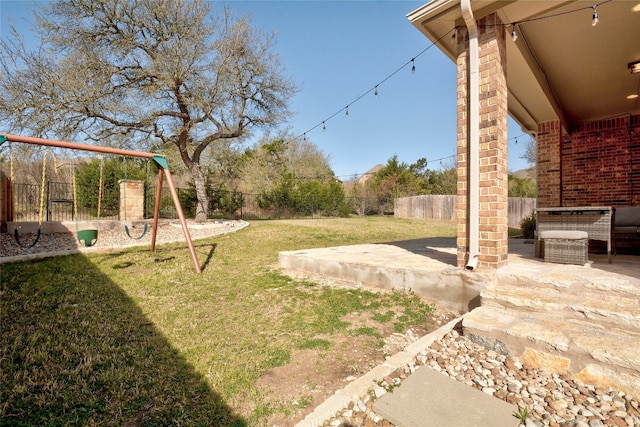 view of yard featuring a patio area, a playground, and a fenced backyard