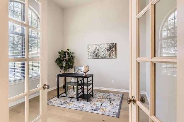 office area with french doors, baseboards, and wood finished floors