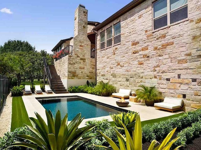 view of swimming pool featuring stairway, a fenced in pool, a patio, and fence