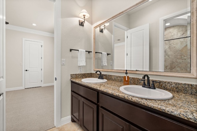 bathroom featuring double vanity, ornamental molding, baseboards, and a sink