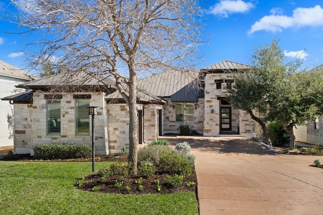 908 Crestone Stream Dr, Austin, TX 78738 - view of front of home with a standing seam roof, stone siding, a metal roof, a front lawn, and concrete driveway
