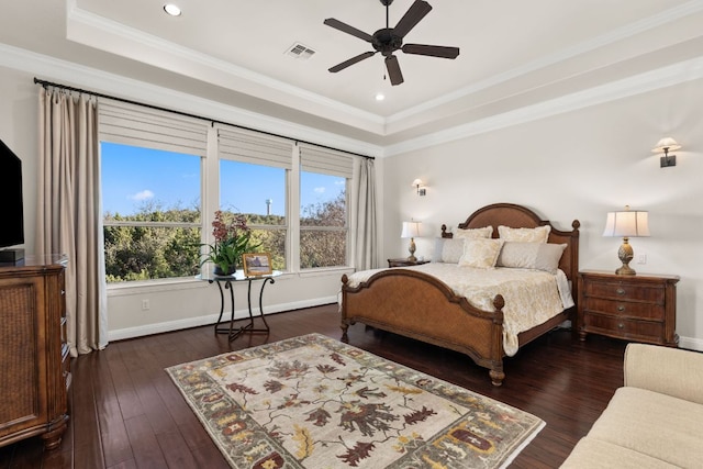 bedroom featuring visible vents, a raised ceiling, dark wood-style floors, and crown molding