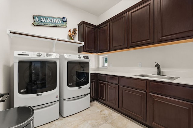 clothes washing area with washing machine and dryer, cabinet space, and a sink